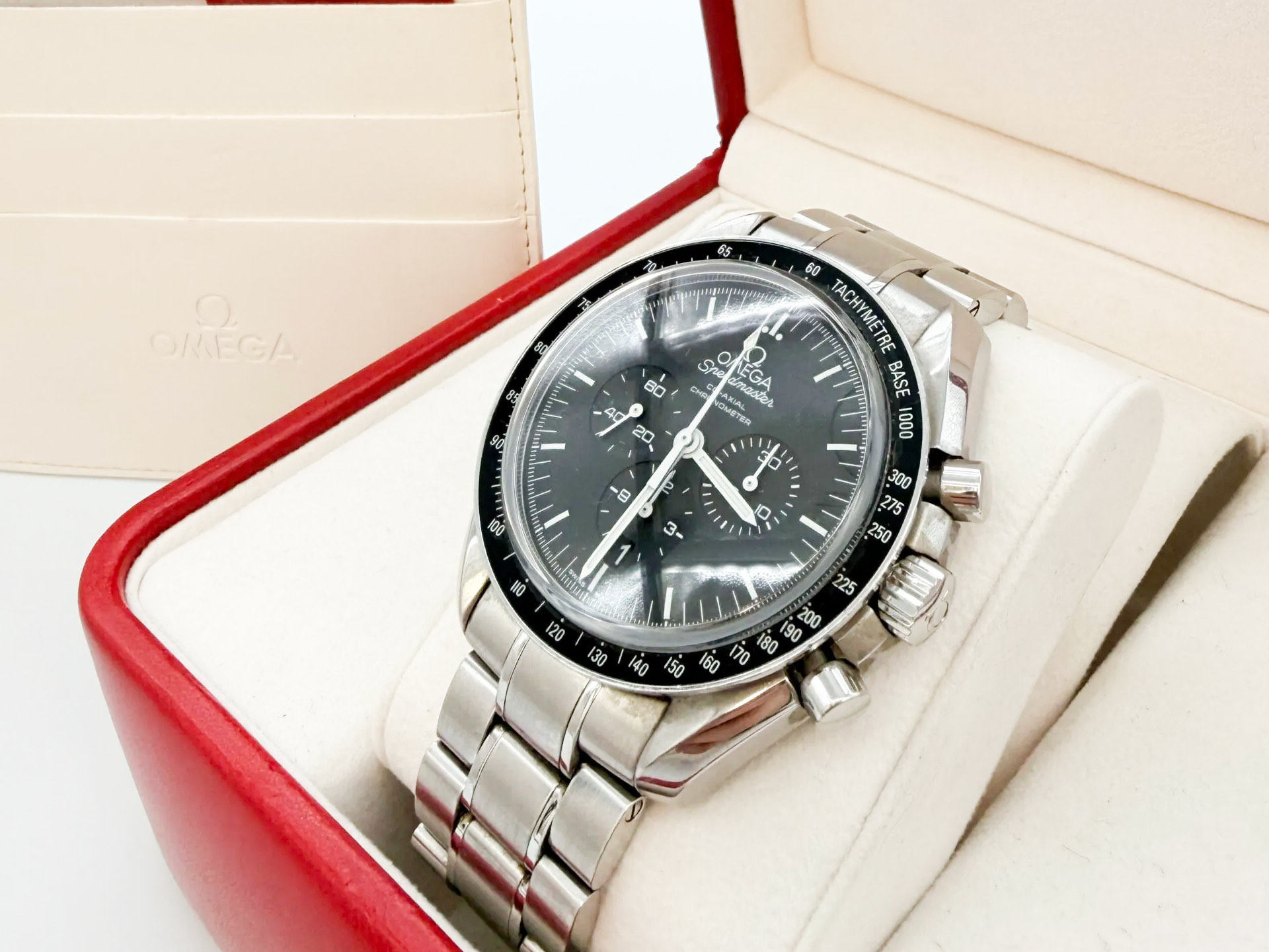 Omega Speedmaster dans écrin — rachat Cartier et Omega Paris